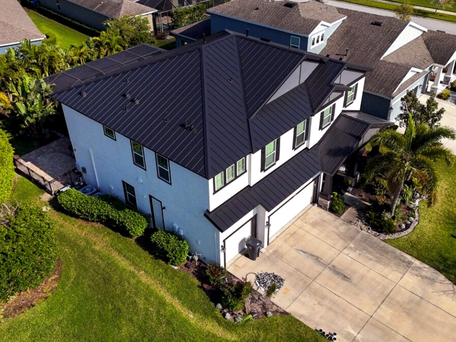 Completed matte-black standing-seam metal roof on a two-story home