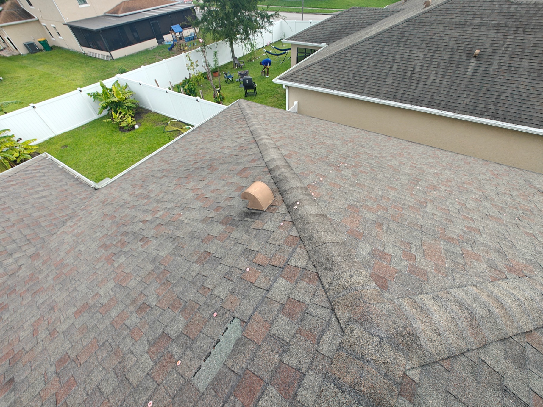 Aerial drone view of a storm-damaged shingle roof in Central Florida