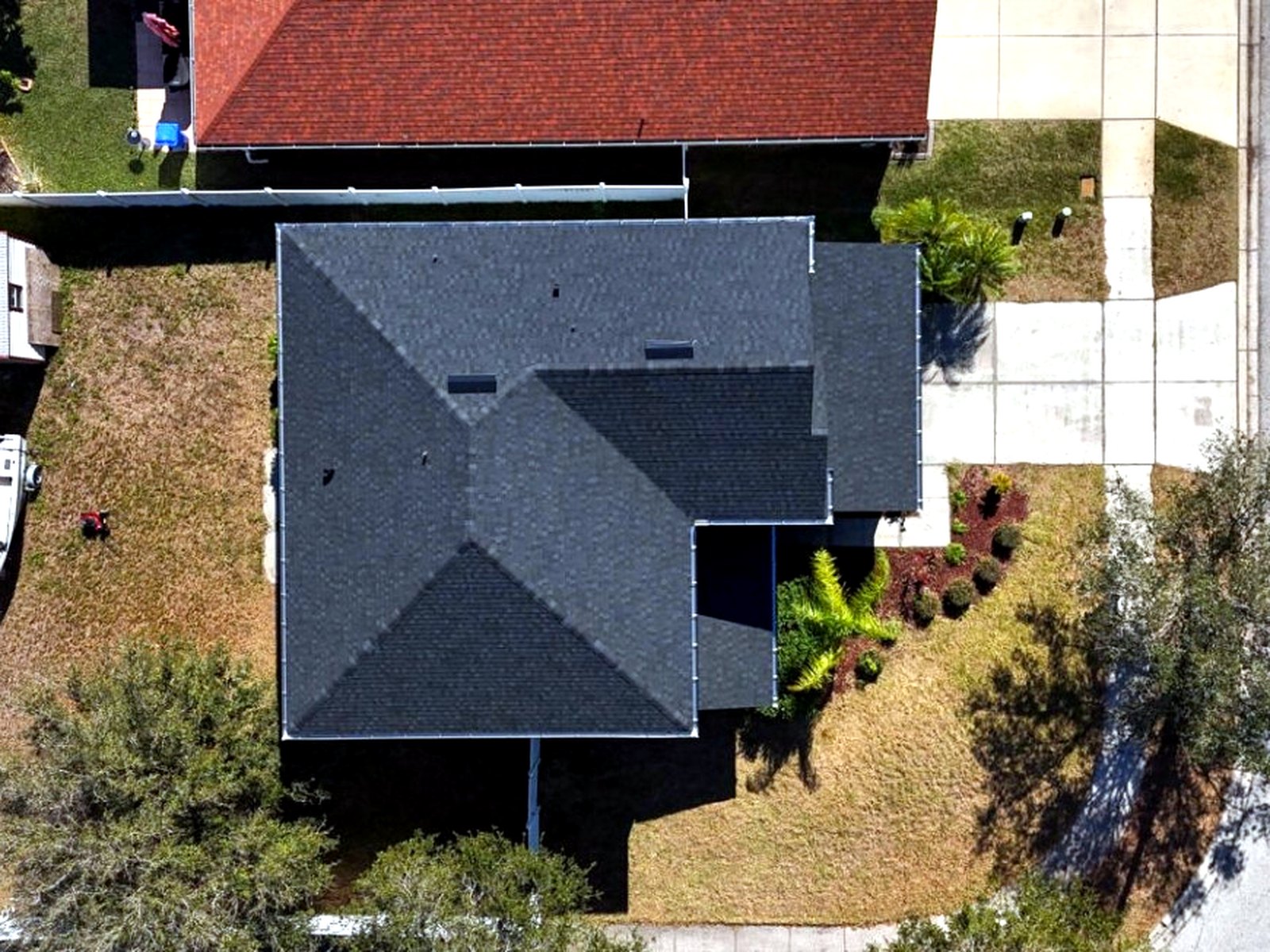 Aerial view of a completed charcoal architectural shingle hip roof in Kissimmee